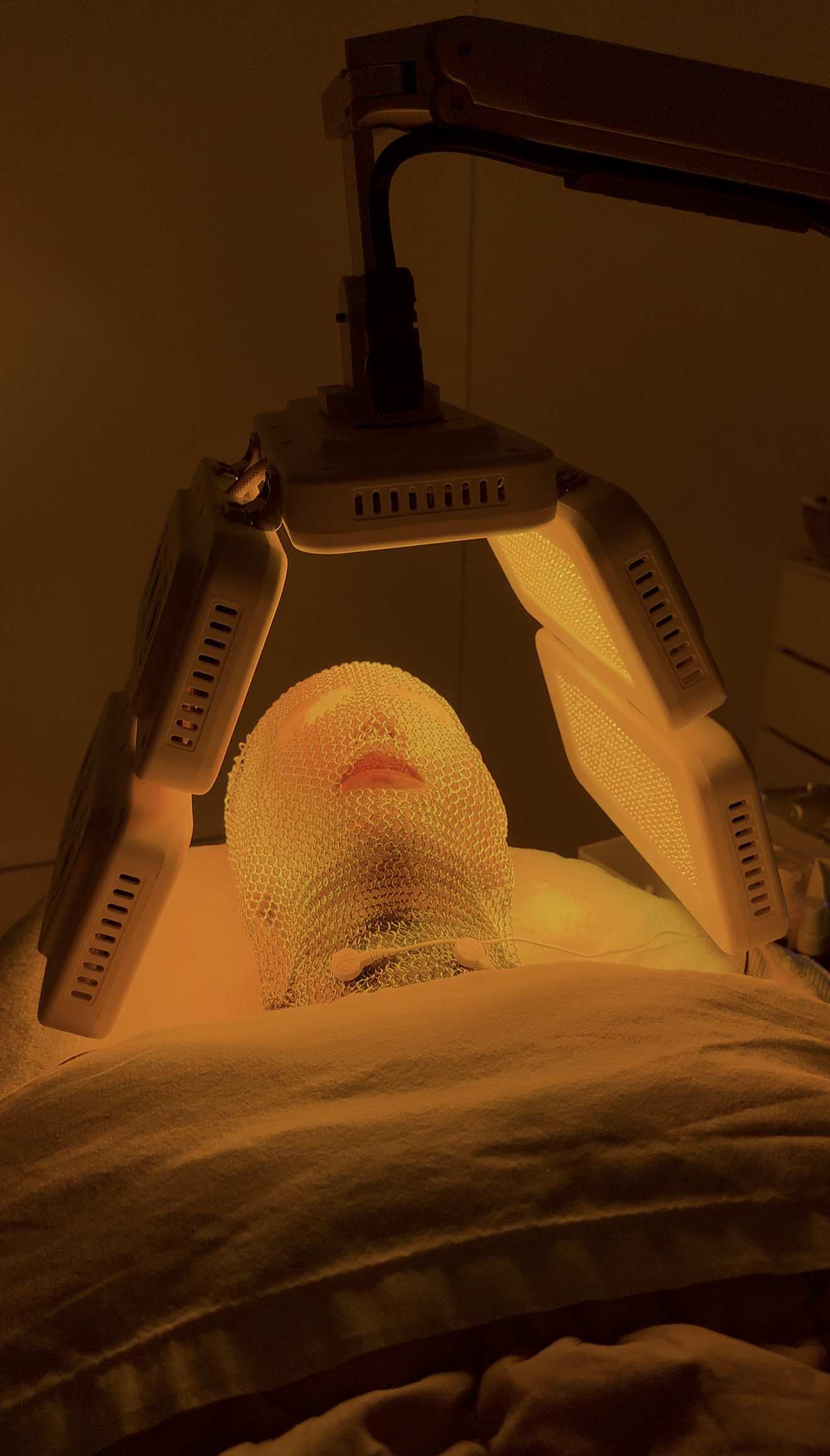 DermoLed 7 LED phototherapy facial treatment session with orange light mode